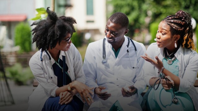 This is a picture of doctors talking and smiling outside.